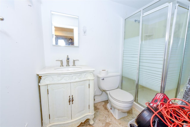 bathroom with toilet, vanity, and a shower with door