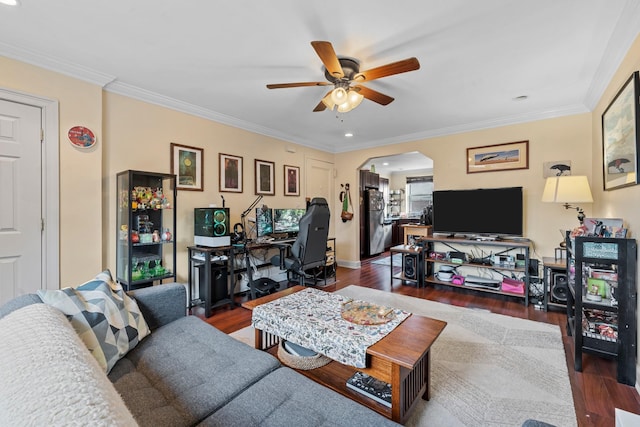 living room featuring ceiling fan, crown molding, and dark wood-type flooring