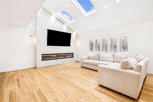 living room with a premium fireplace, light hardwood / wood-style flooring, and high vaulted ceiling