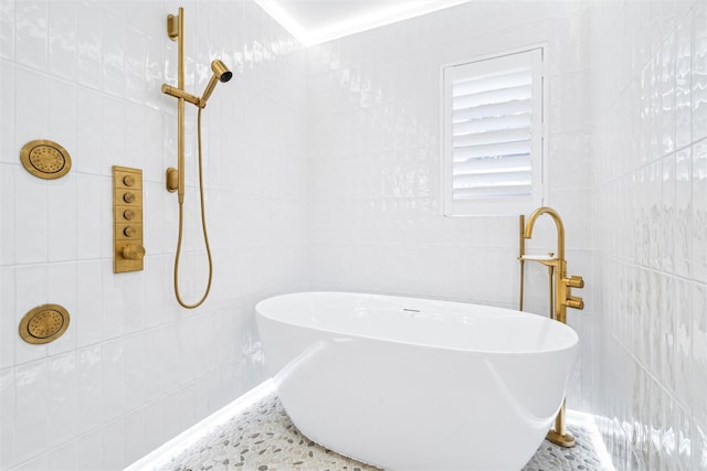 bathroom with a tub to relax in and sink