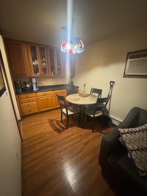 dining room featuring a wall mounted AC and dark wood-type flooring