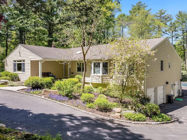 ranch-style house featuring covered porch and a garage