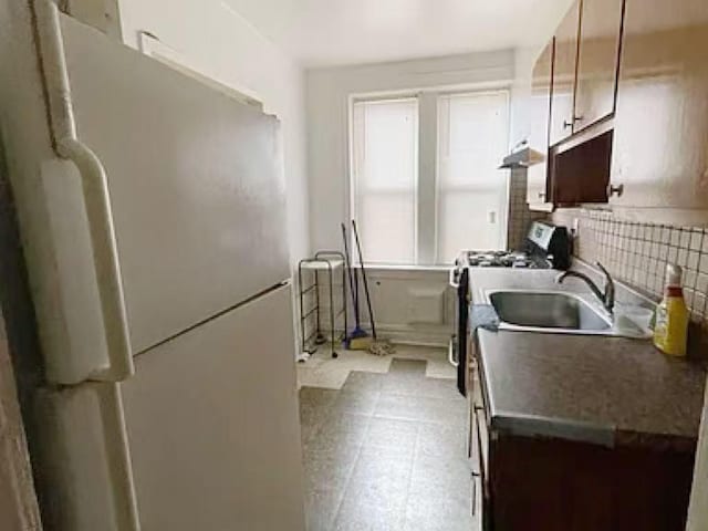 kitchen featuring sink, white fridge, and range