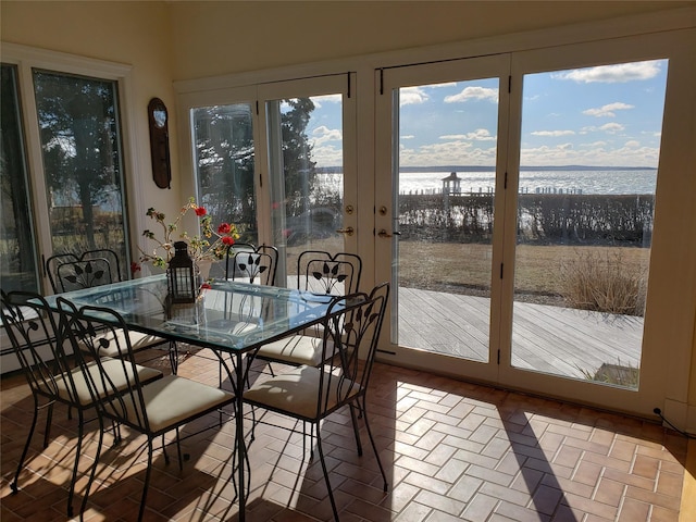 sunroom featuring a water view