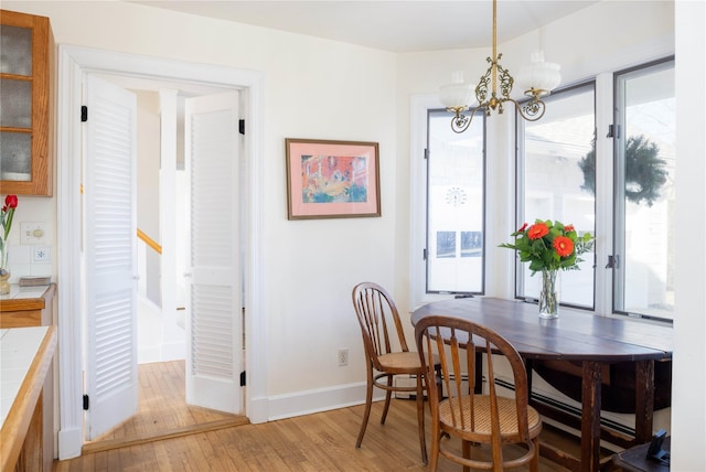 dining room featuring an inviting chandelier, a healthy amount of sunlight, and light wood-type flooring