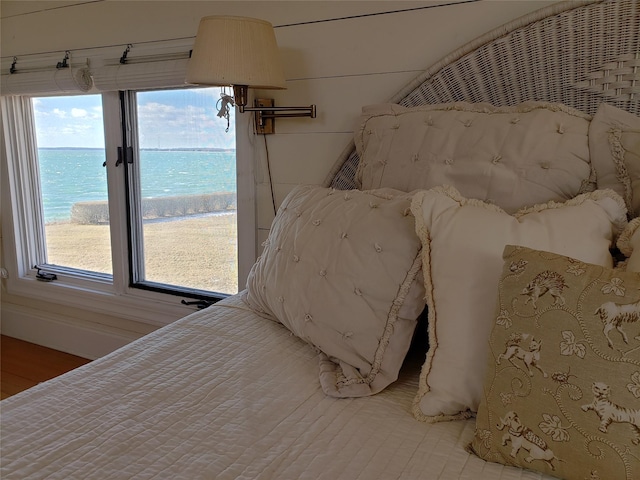 unfurnished bedroom featuring hardwood / wood-style flooring and a water view