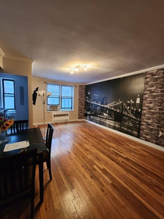 dining room with hardwood / wood-style floors, cooling unit, radiator, and ornamental molding