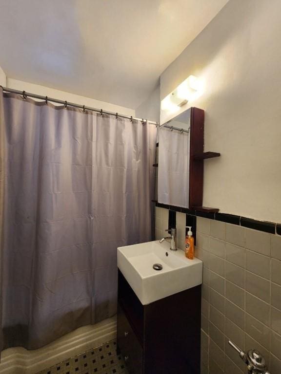 bathroom featuring vanity and tile walls