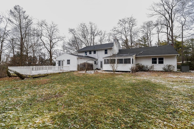 back of property featuring a wooden deck, a sunroom, and a yard