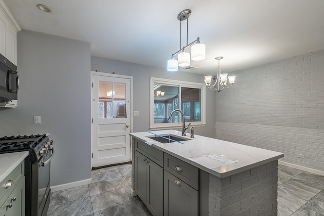 kitchen with an island with sink, sink, white cabinets, light stone counters, and gas stove