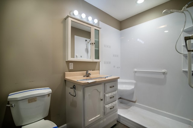 bathroom with vanity, a shower, and toilet