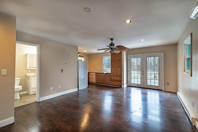 unfurnished living room featuring french doors, ceiling fan, dark wood-type flooring, and baseboard heating