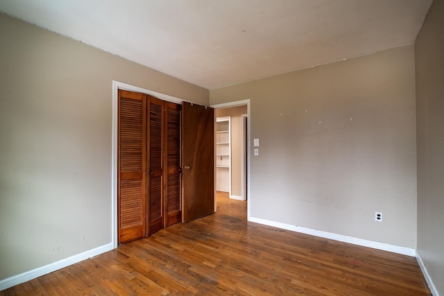 unfurnished bedroom featuring hardwood / wood-style floors and a closet