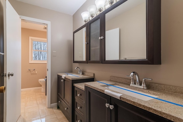 bathroom featuring tile patterned flooring, vanity, and toilet