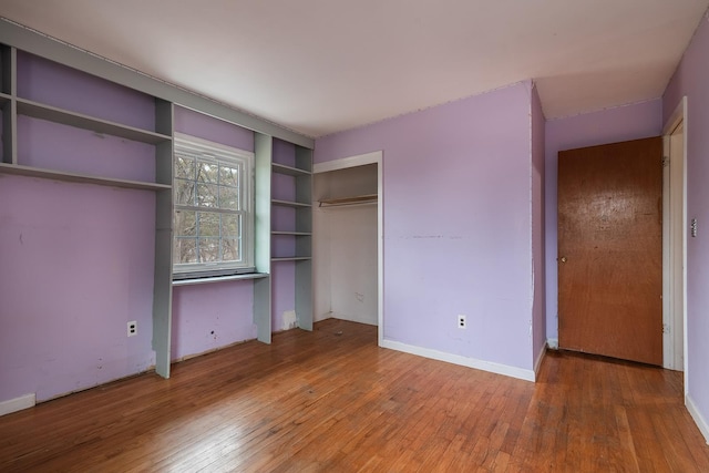 unfurnished bedroom with wood-type flooring and a closet