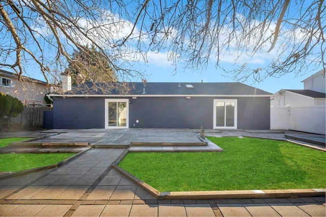 back of house with a yard and a patio