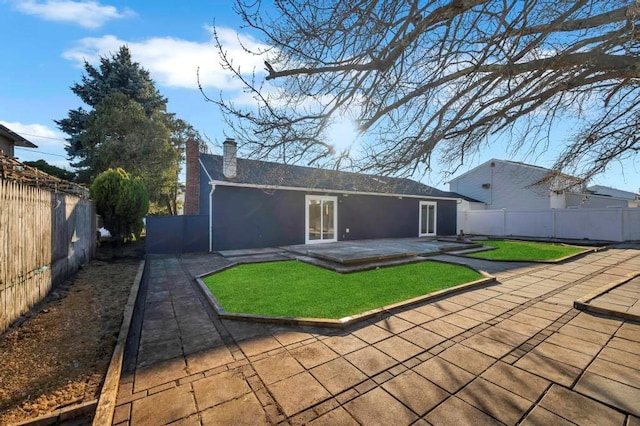 back of house featuring a lawn and a patio