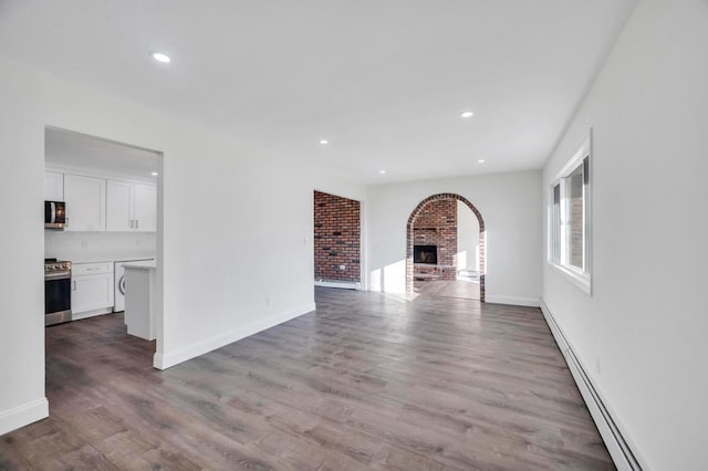 unfurnished living room featuring a fireplace, a baseboard radiator, and light hardwood / wood-style flooring