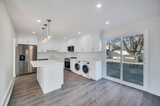 kitchen with a center island, a baseboard radiator, decorative light fixtures, white cabinets, and appliances with stainless steel finishes