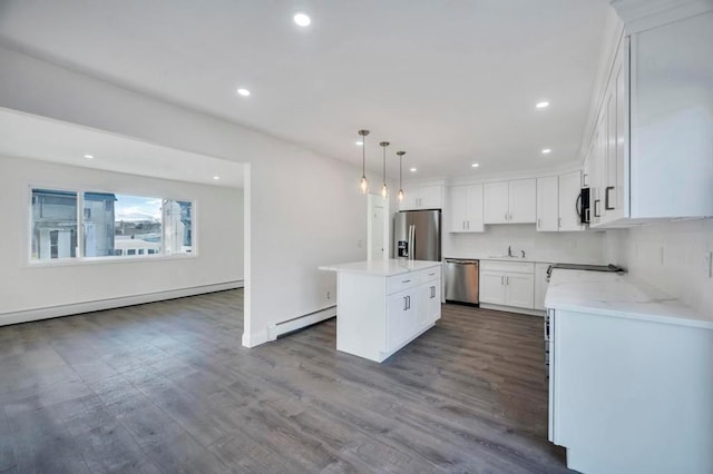 kitchen with a center island, white cabinets, a baseboard radiator, wood-type flooring, and stainless steel appliances