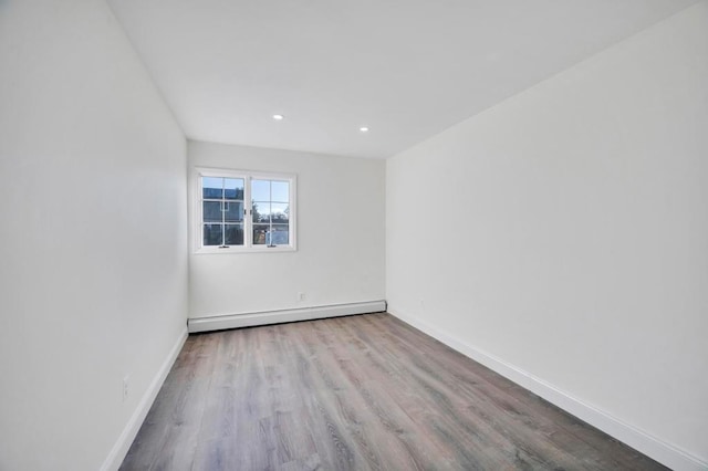 unfurnished room featuring light hardwood / wood-style flooring and a baseboard radiator