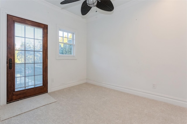 carpeted empty room featuring ceiling fan and crown molding