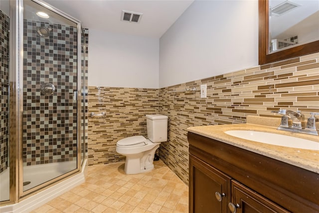 bathroom with vanity, tile patterned flooring, toilet, walk in shower, and tile walls