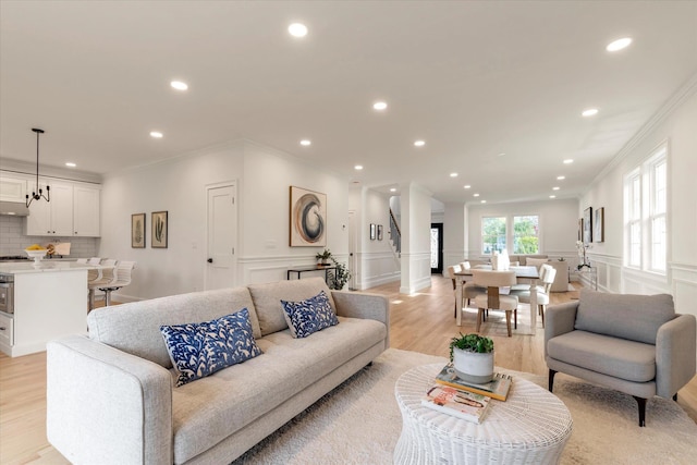 living room with light wood-type flooring and ornamental molding