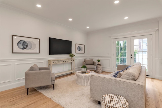 living room featuring ornamental molding, light hardwood / wood-style flooring, and french doors