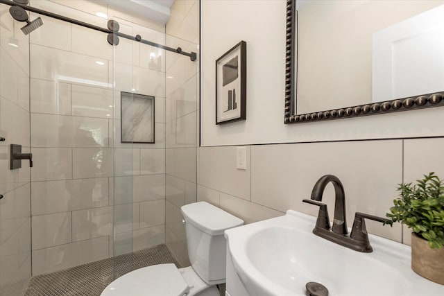 bathroom with an enclosed shower, toilet, sink, and tile walls