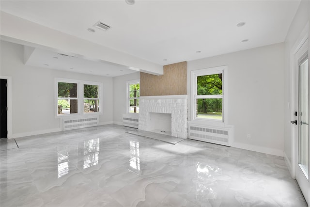 unfurnished living room with a fireplace and radiator