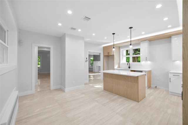 kitchen with pendant lighting, a kitchen island, and sink