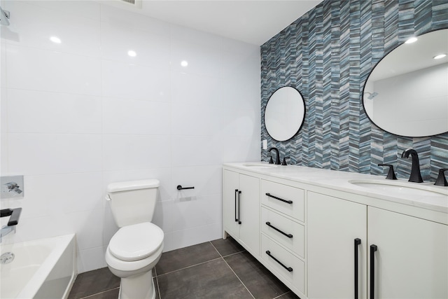 bathroom with tile patterned flooring, vanity, tile walls, and toilet