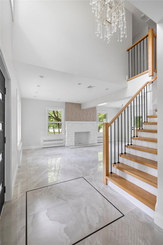 unfurnished living room featuring a fireplace and a chandelier