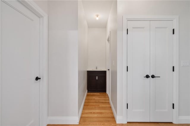 corridor featuring light hardwood / wood-style flooring and sink