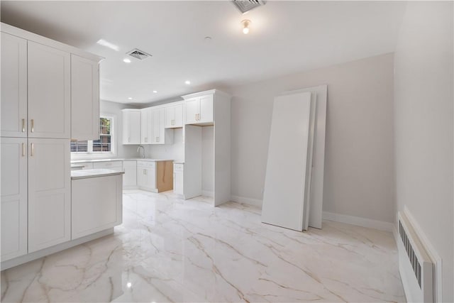 kitchen featuring white cabinetry and sink