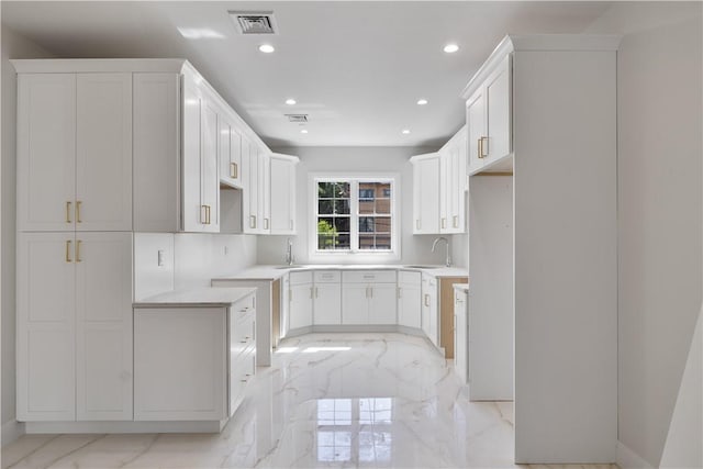 kitchen featuring white cabinets, tasteful backsplash, and sink