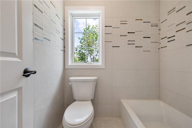 bathroom featuring a tub to relax in and toilet