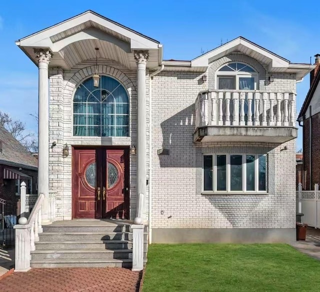 exterior space featuring a balcony and a front lawn