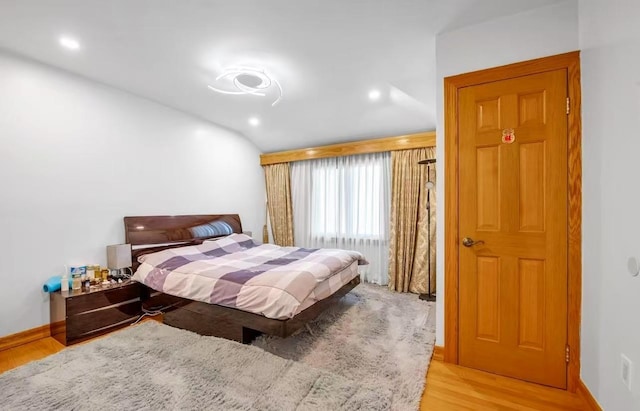 bedroom with light hardwood / wood-style flooring and lofted ceiling