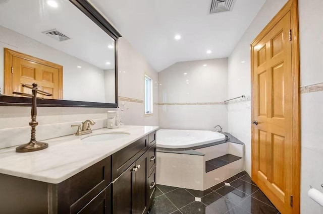 bathroom featuring tile patterned flooring, vanity, lofted ceiling, and a bath