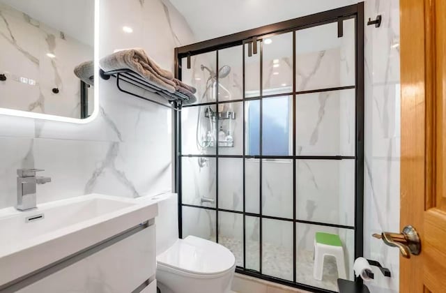 bathroom featuring vanity, backsplash, toilet, tile walls, and walk in shower