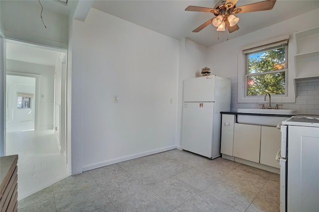 kitchen with white cabinets, range, white refrigerator, decorative backsplash, and sink