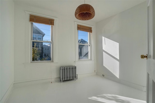 unfurnished room featuring plenty of natural light and radiator heating unit