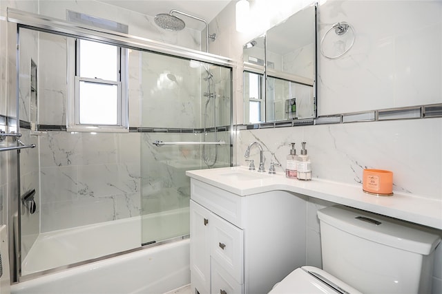 full bathroom with shower / bath combination with glass door, vanity, tasteful backsplash, and toilet