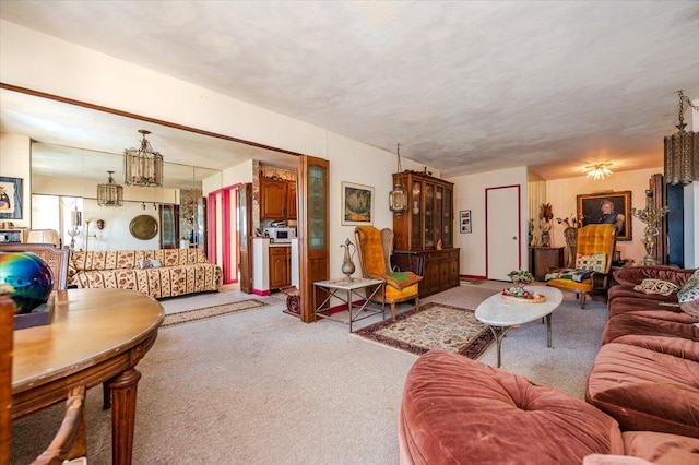 carpeted living room featuring a chandelier and a textured ceiling