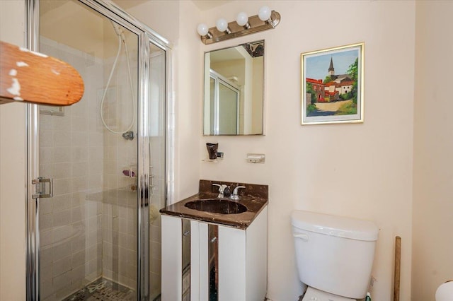 bathroom featuring an enclosed shower, vanity, and toilet