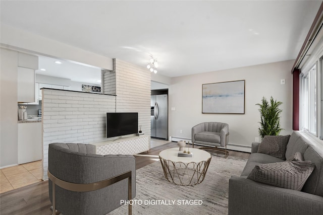 living room featuring baseboard heating and light hardwood / wood-style floors