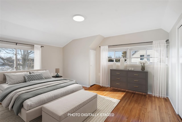 bedroom with lofted ceiling and light hardwood / wood-style floors