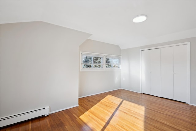 bonus room with lofted ceiling, wood-type flooring, and a baseboard heating unit